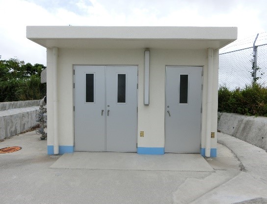 白い壁に灰色のドアが三つ付いた建物の写真