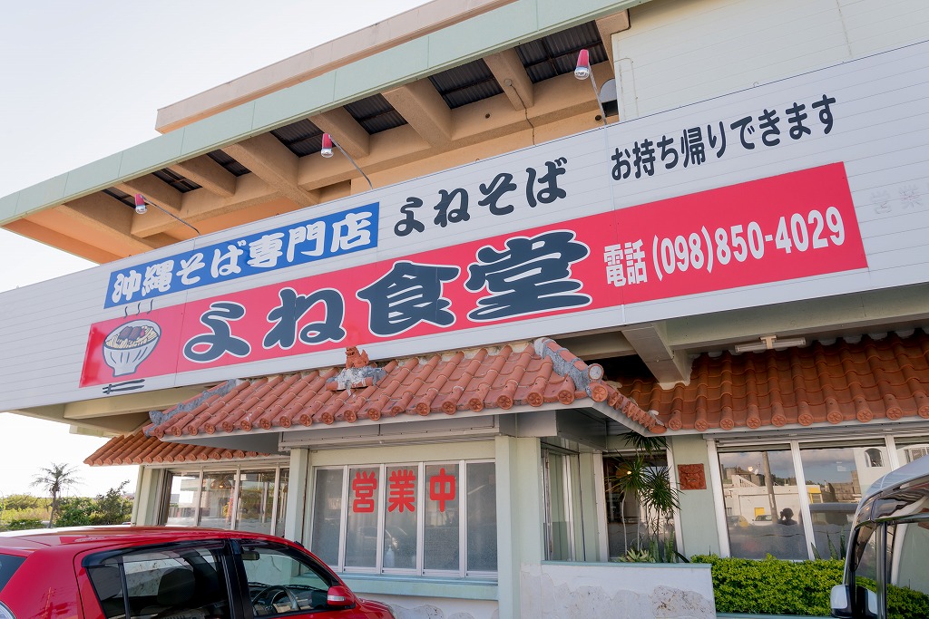 よね食堂と書かれた大きな看板と瓦屋根の店舗の写真