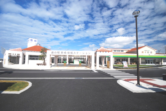 青空の下道の駅「豊崎」の外観を道路側から撮影した写真