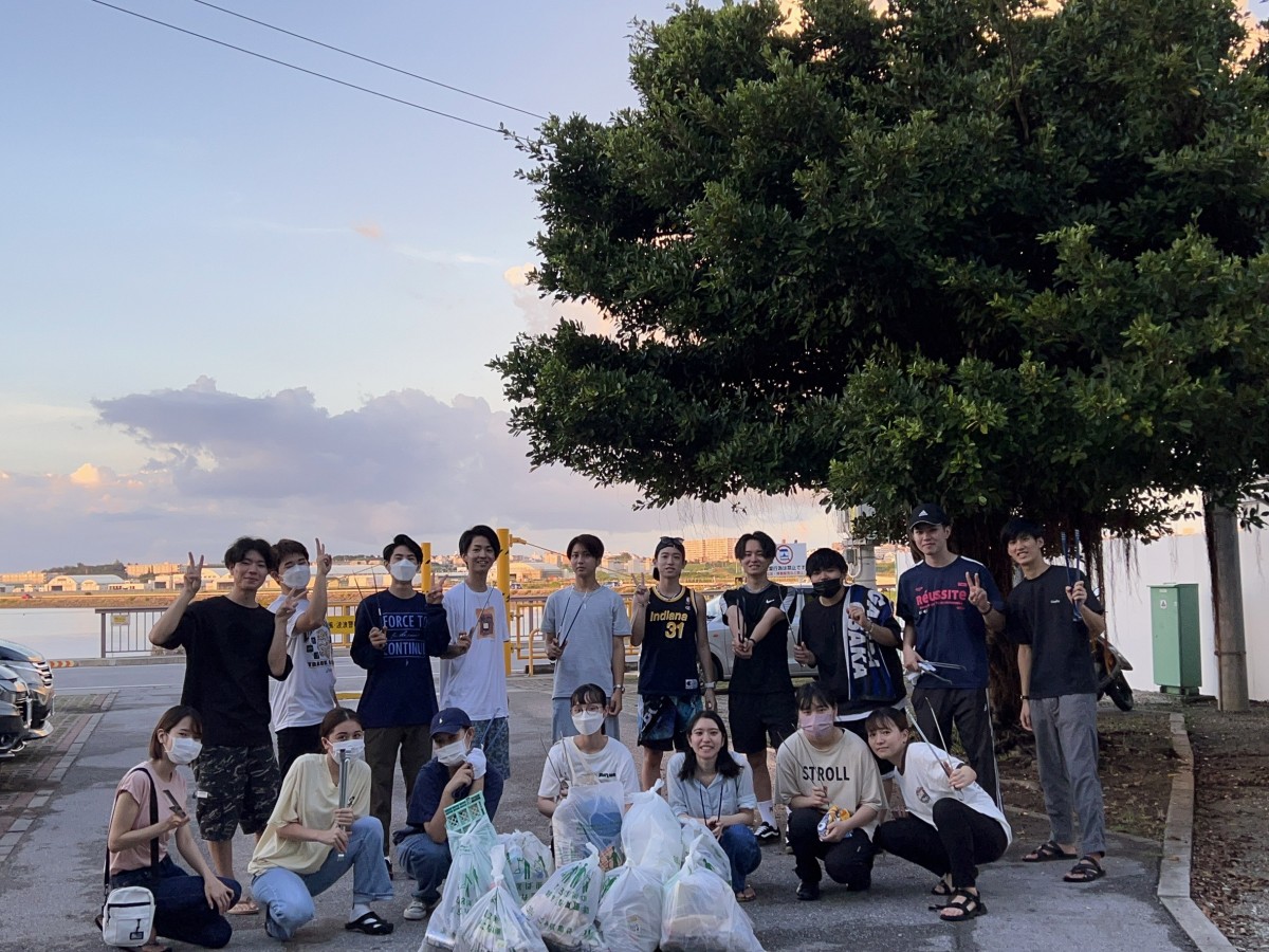 沖縄国際大学学生環境委員会の学生たちがゴミ袋を前に並んでいる写真
