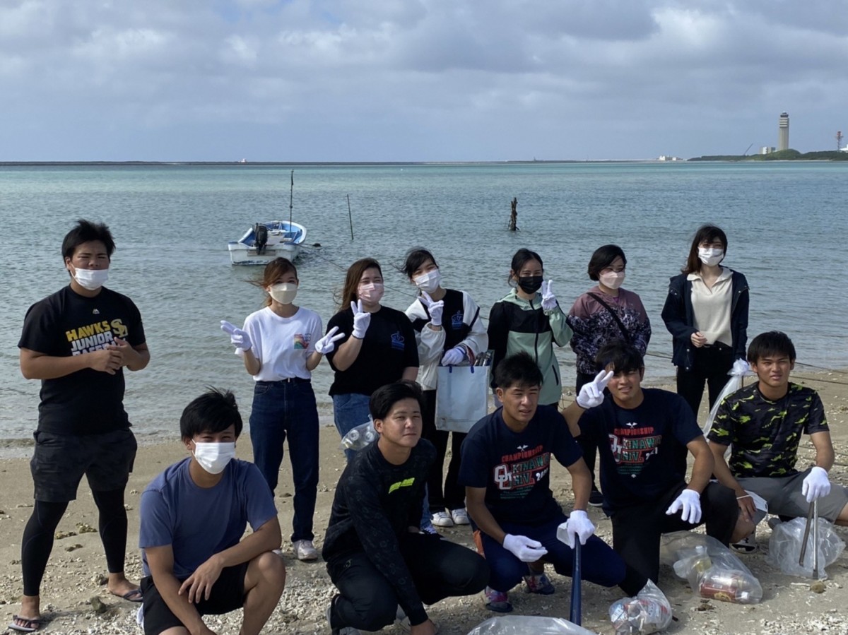 沖縄大学経法商学科の成定ゼミの学生たちがゴミ袋を前に並んでいる写真
