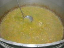 グランドケトルの中のスープ上の灰汁を取っている写真