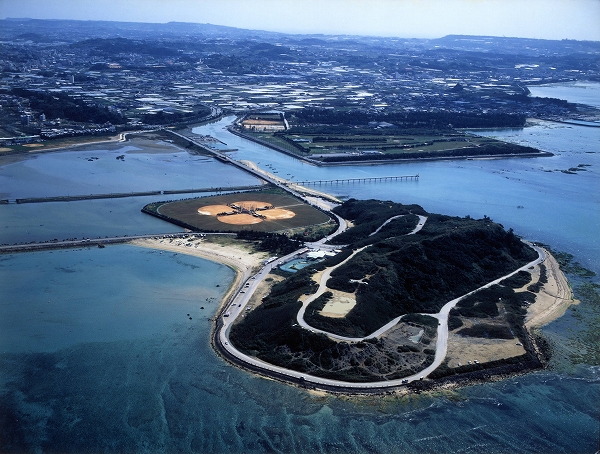本島から大きな橋がかかっていて、島を一周するような大きい道が敷かれている瀬長島を、上の方から撮影した写真