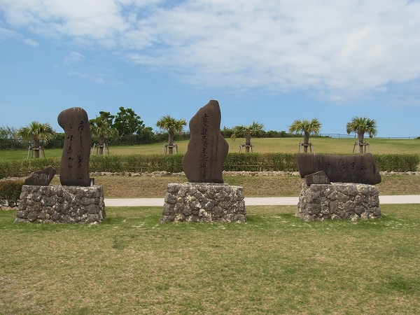 石の台座に乗った三つの石碑が、芝生の上に並んで立っている写真