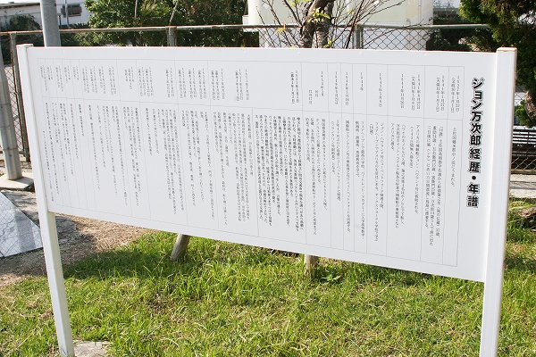 「ジョン万次郎 経歴・年譜」と書かれた説明文のある看板が芝生の上に立っている写真