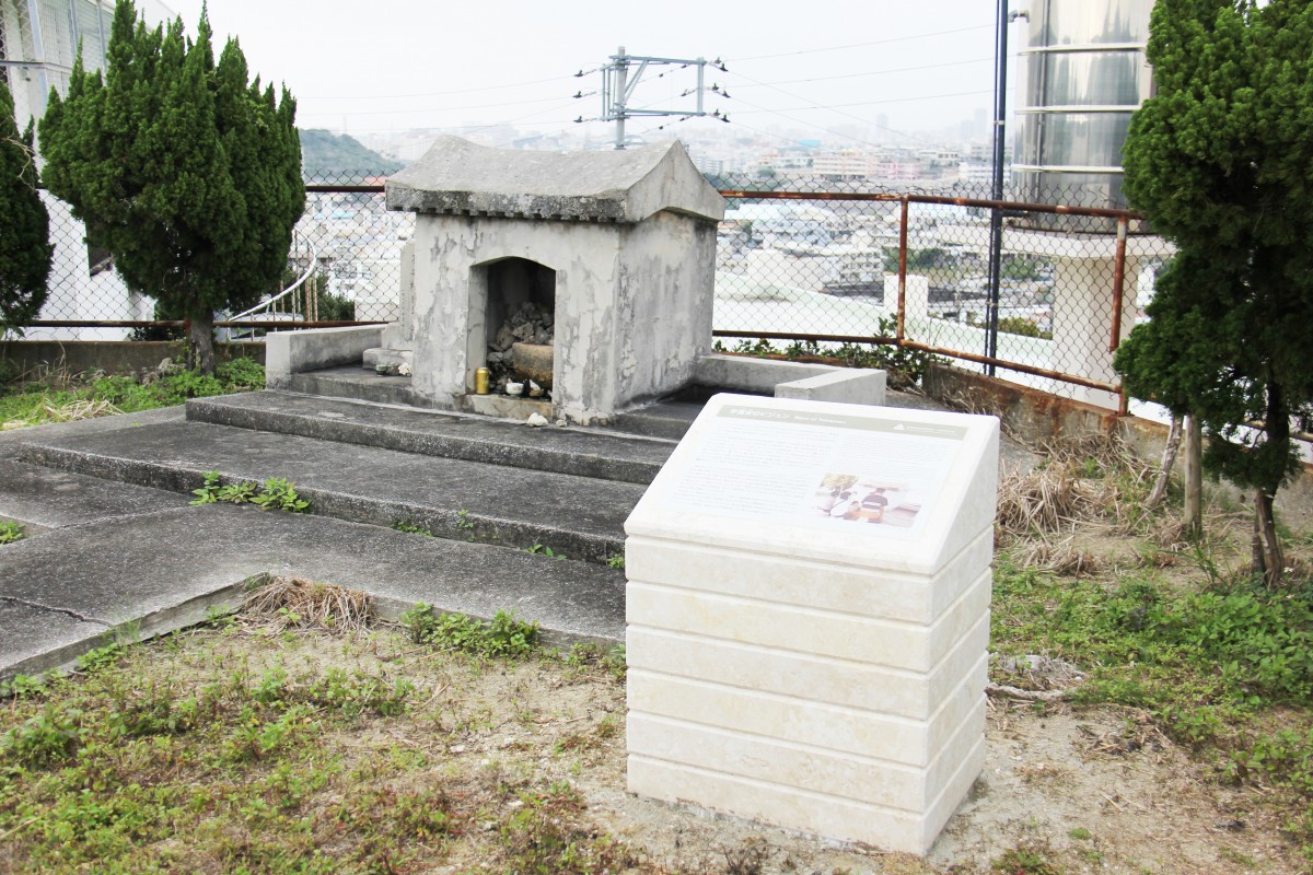 小さな祠の前に、説明が書かれた白いオブジェが置かれている写真
