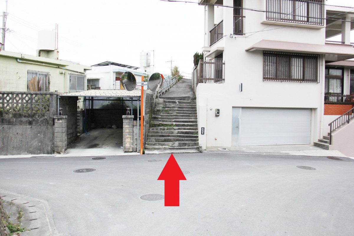 赤い矢印で、住宅の間にある細い階段を示している写真