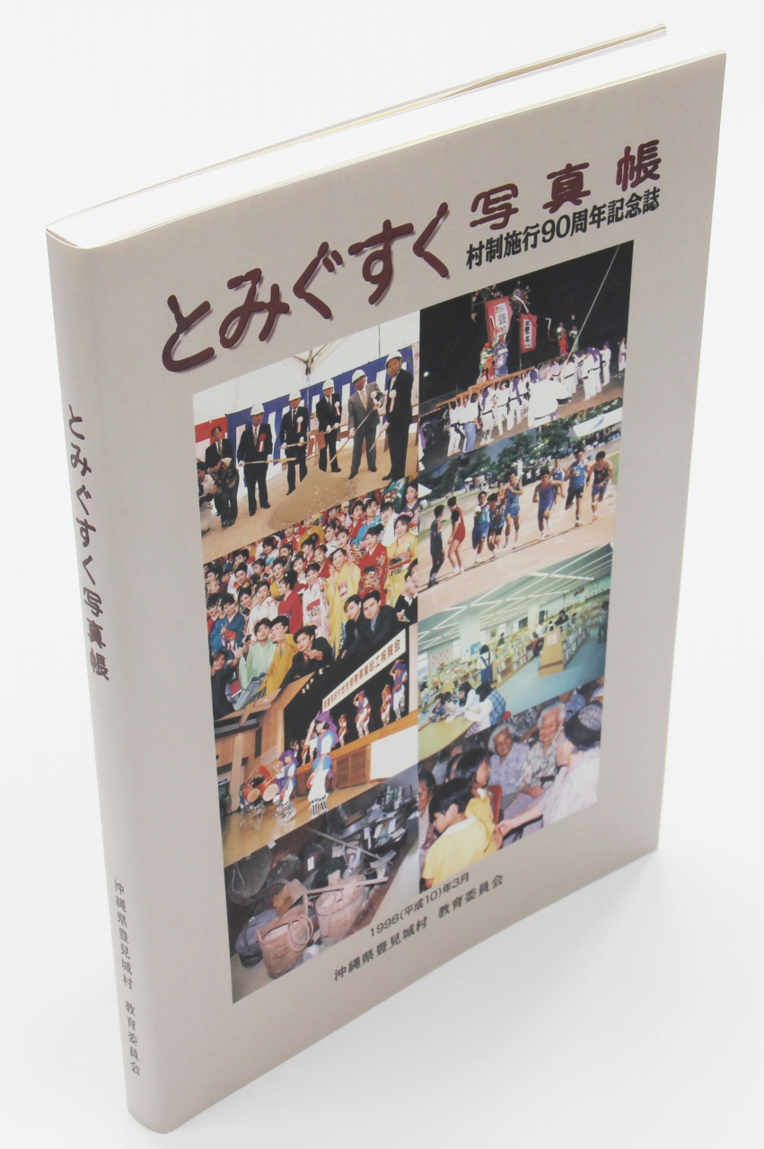 「とみぐす写真帳」という題に縦二列横三列、計八枚の写真が並んだ表紙の本が立っている写真