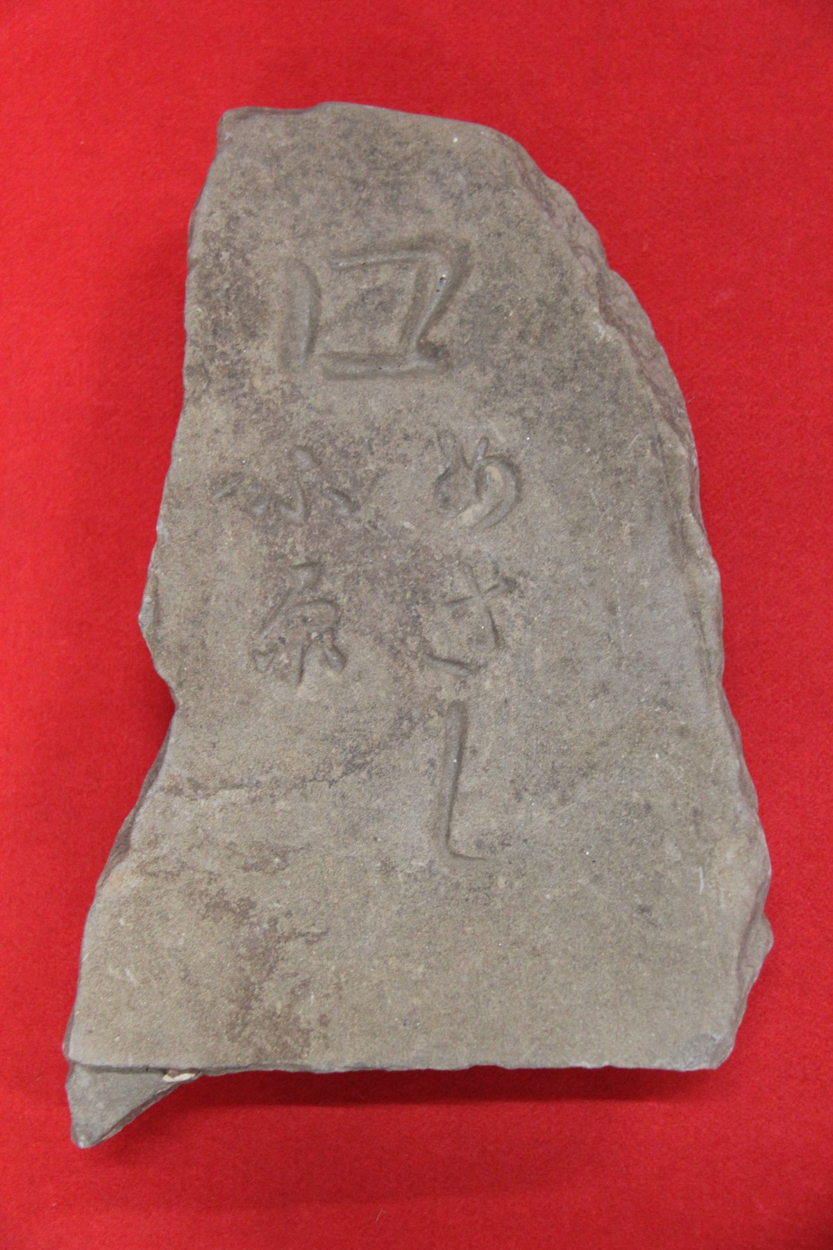 赤色の背景で「ロ めさしふ原」と彫られている印部石の写真