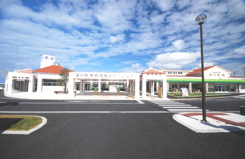 白い壁にオレンジ色の瓦屋根の道の駅 豊崎情報ステーションの写真