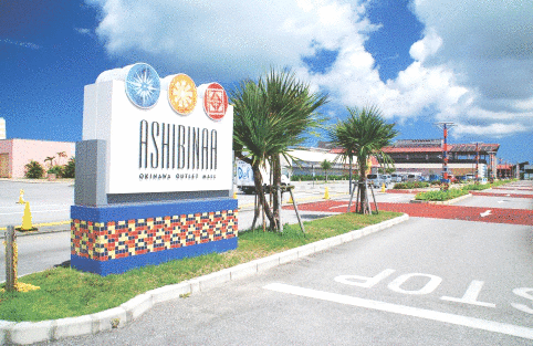 「ASIBINAA」と書かれた看板が駐車場の出口付近に建てられている写真