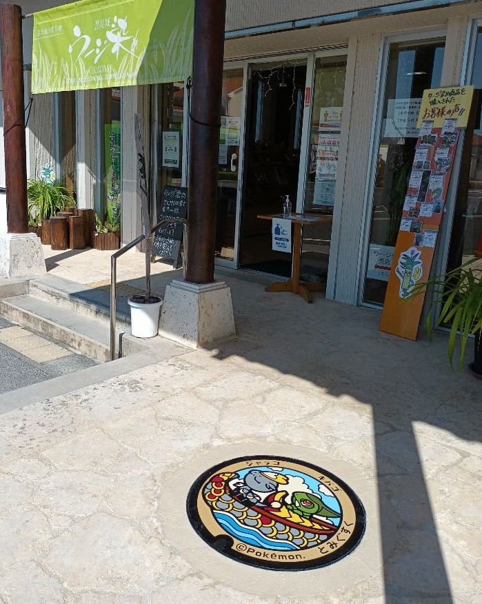 お店の外観とその手前の地面にポケふたが設置されている写真