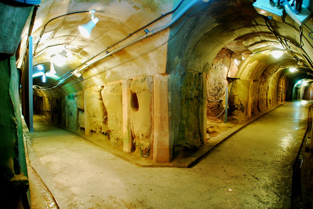左右に伸びる、明かりのついたトンネル(壕)の写真(旧海軍指令部壕 とみぐすく観光ガイドへリンク)