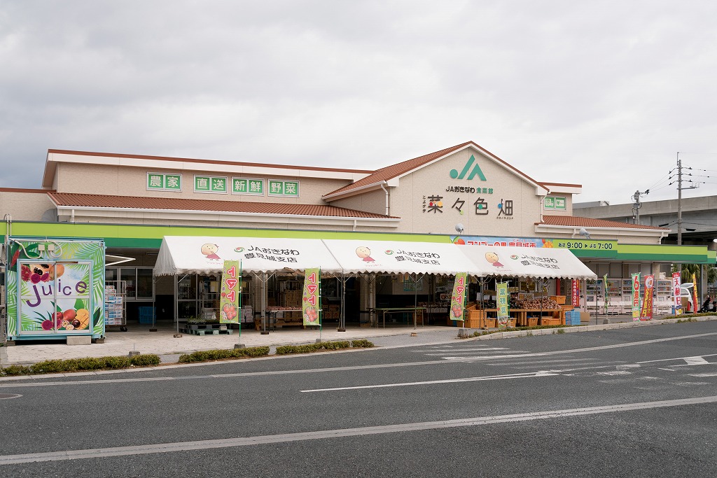 茶色屋根の横長のJAおきなわ食菜館とその前に設置された仮設テントの写真