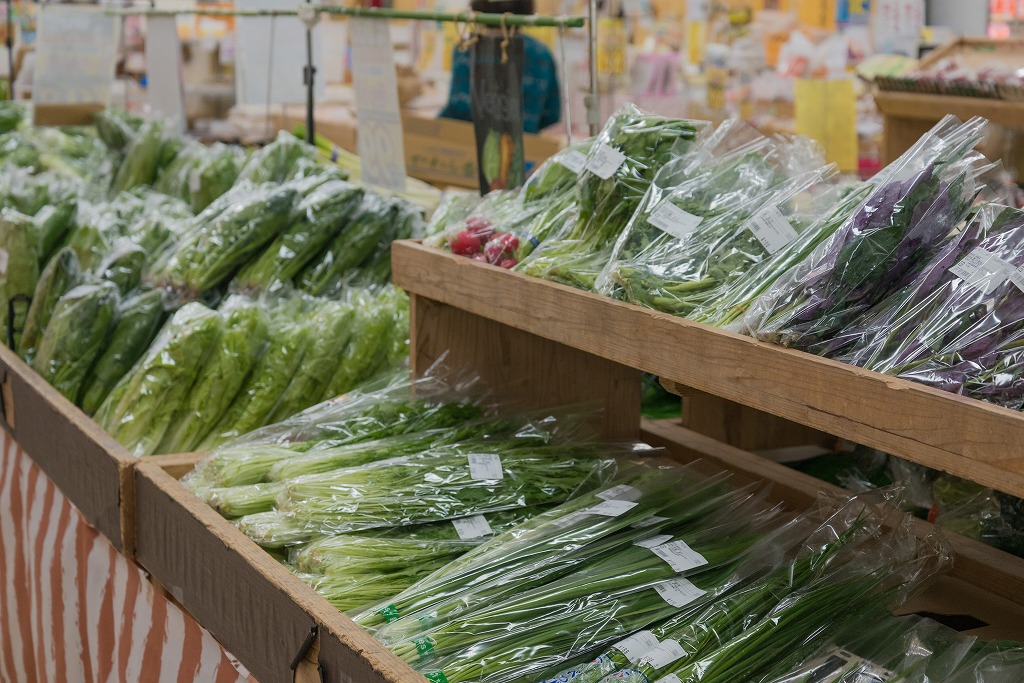 木の箱に並べられた、緑野菜の数々の写真