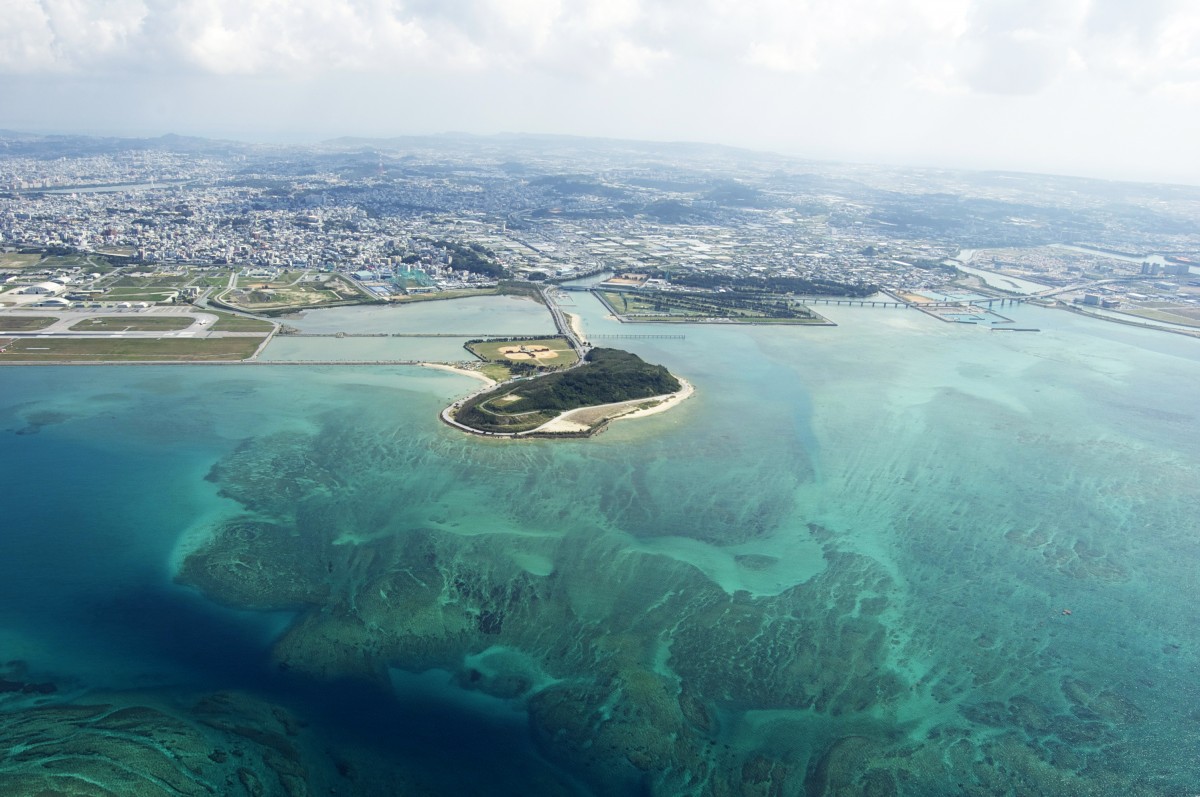 大陸の街と海に浮かぶ島を上空から写した航空写真
