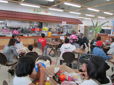 食事コーナーの前で客が座って食事などをしている写真